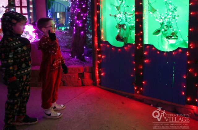 two children looking at animated reindeer displays at a holiday event