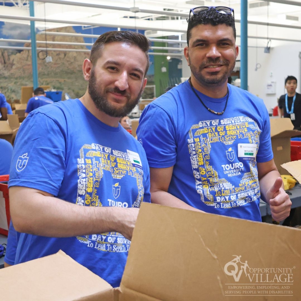 two men in blue shirts volunteering by filling boxes