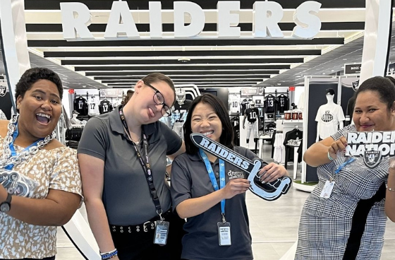 group of four people standing in a raiders retail store