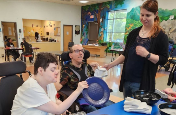 group of people together learning to wash dishes in a day habilitation program