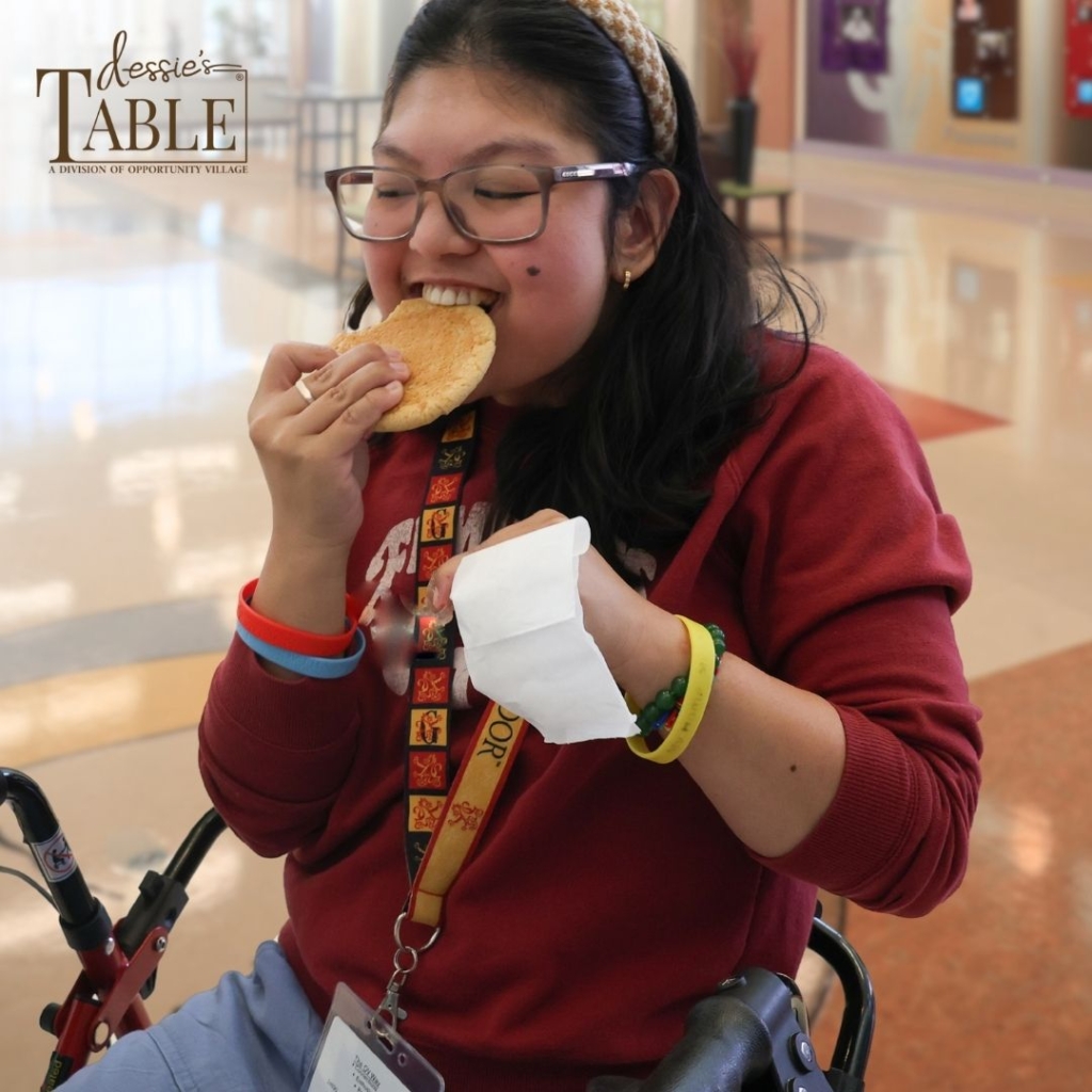 person biting into a cookie with a happy look on their face