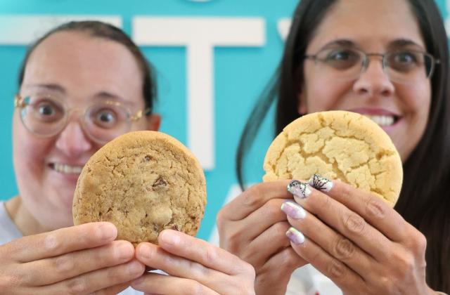 photo of two people each holding a cookie up close to the camera